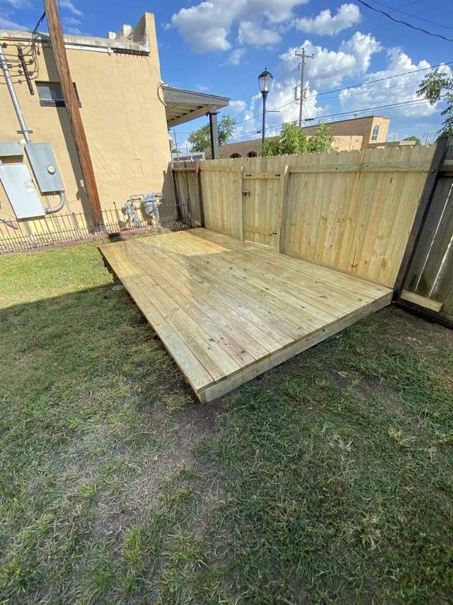 Finished wood deck in front of a new wood fence and gate