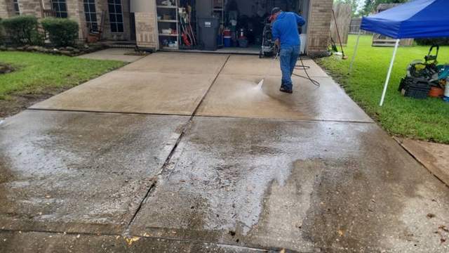 Crew pressure washing a driveway